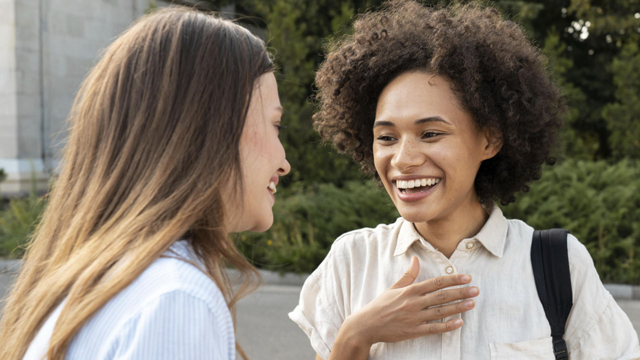 Fotografia de mulheres conversando entre si sorrindo.