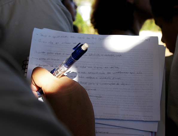 Fotografia de uma pessoa que segura uma caneta e um caderno com anotações.