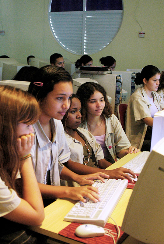 Fotografia de jovens garotas em frente ao computador.