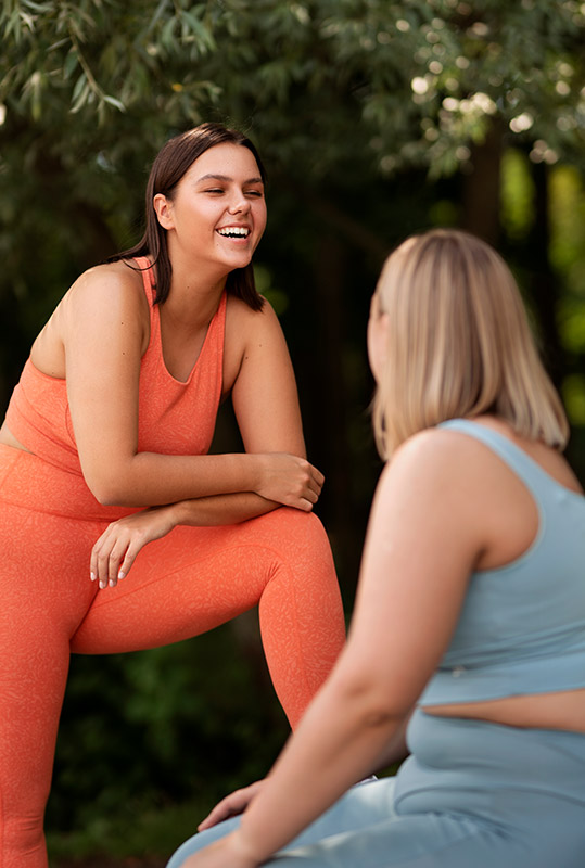 Fotografia de duas mulheres conversando entre si e sorrindo.