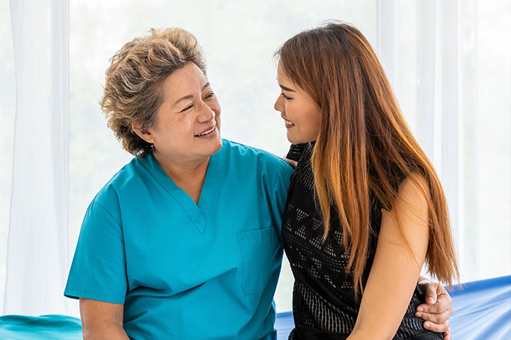 Fotografia de mulheres que se olham e sorriem.