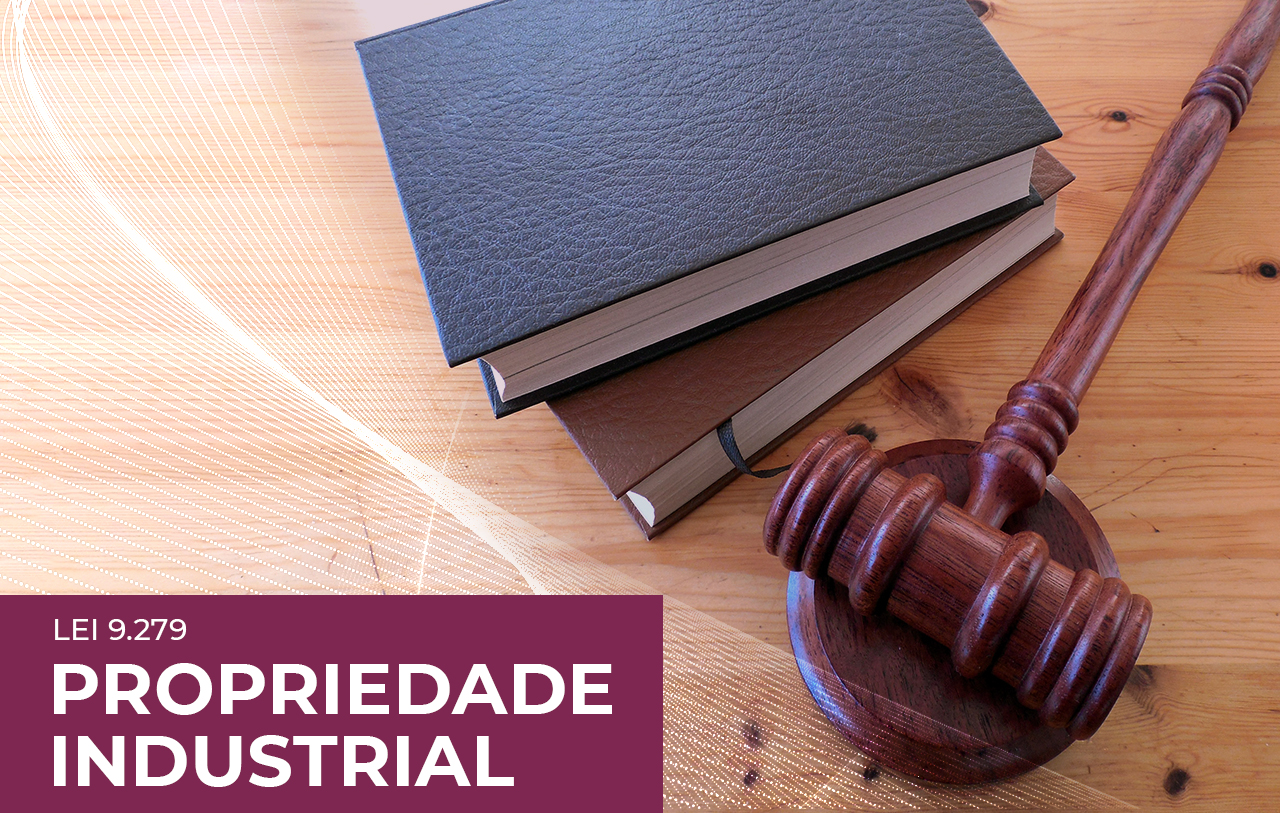Montagem com um martelo de juiz e livros sobre uma mesa de madeira. Na imagem, lê-se: Lei 9.279 - Propriedade Industrial