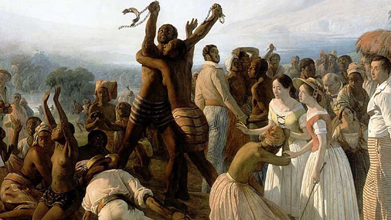 Pintura em cores representando a abolição da escravatura. Duas pessoas negras com o dorso nu se abraçam ao centro do quadro, carregando em suas mãos, algemas abertas. Há várias outras pessoas negras próximas e algumas poucas pessoas brancas também.