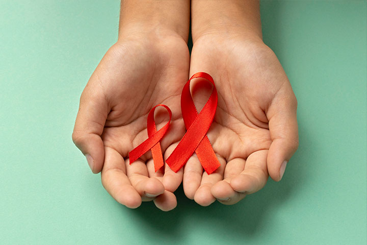 Mãos segurando fitas com o símbolo do combate à Aids.