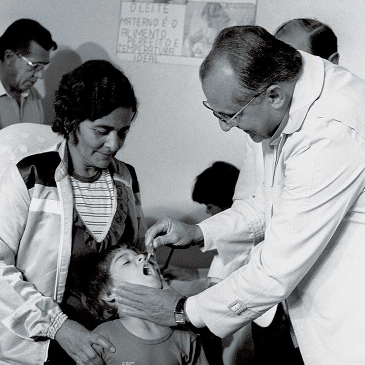 Na foto, o ministro da Saúde, Waldir Arcoverde (1979-1985), vacinando uma criança contra a doença. 17 jun. 1984. 