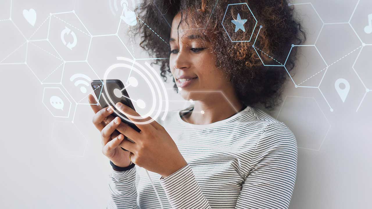 Fonte: Freepik Fotografia de uma mulher negra com cabelo cacheado segurando um celular.