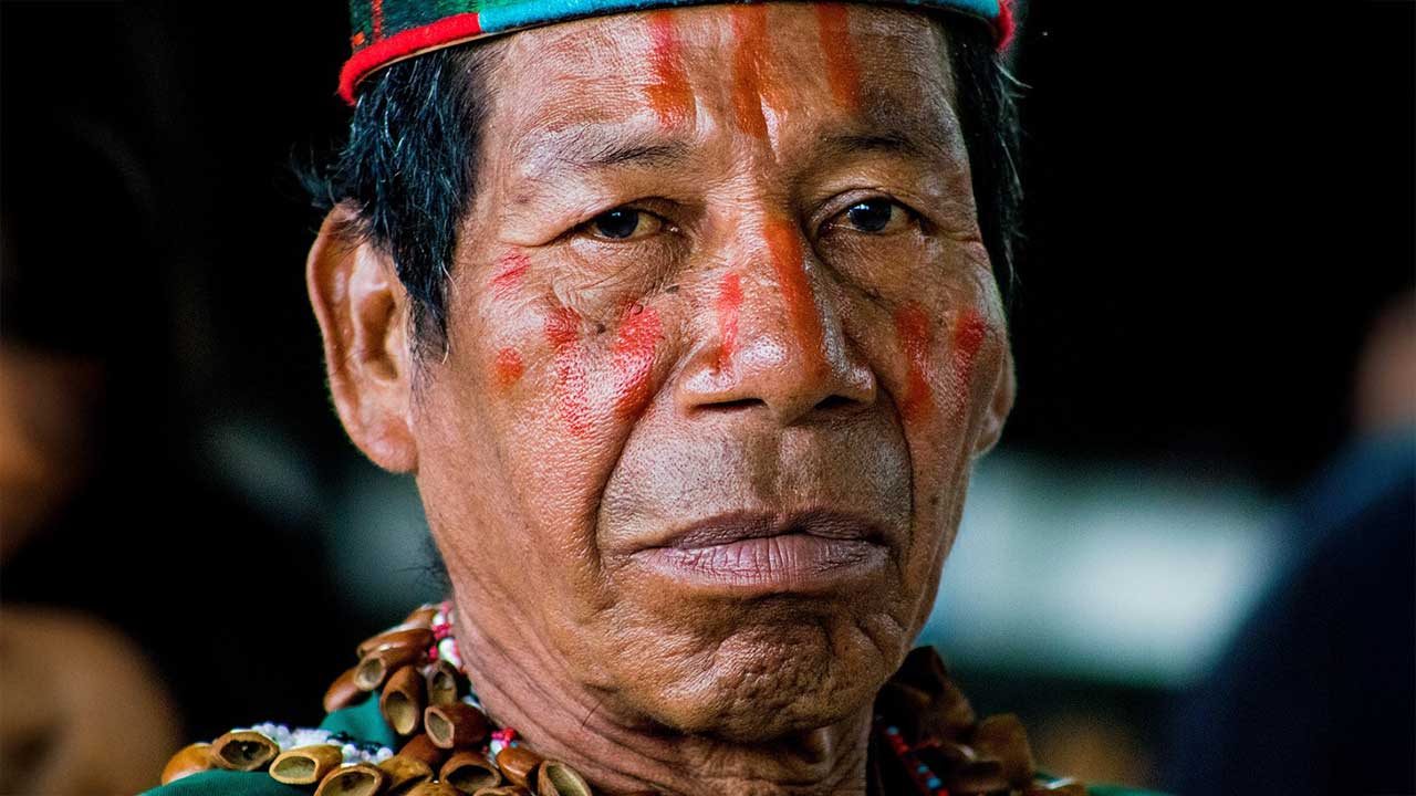 Fotografia de um homem de etnia indígena, ele não sorri para a foto.